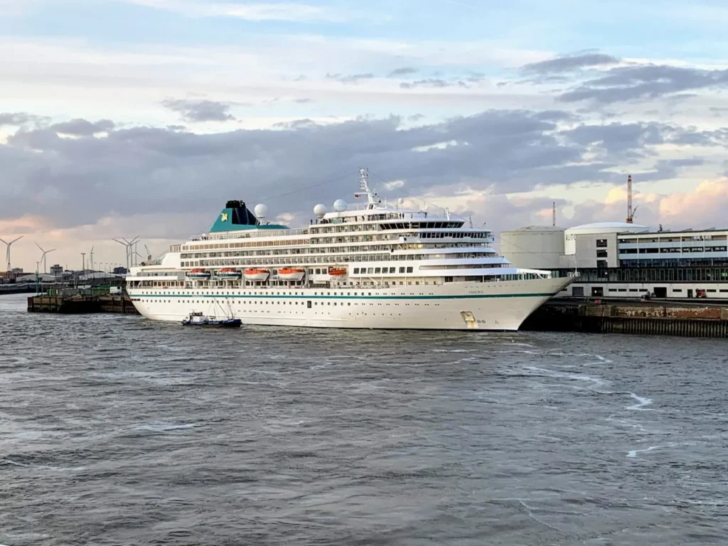 River cruise ship docked in a European city center at sunset