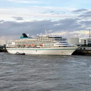 River cruise ship docked in a European city center at sunset