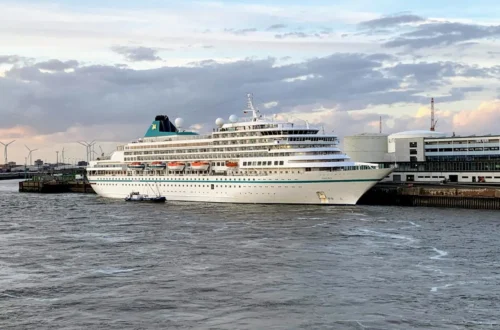 River cruise ship docked in a European city center at sunset