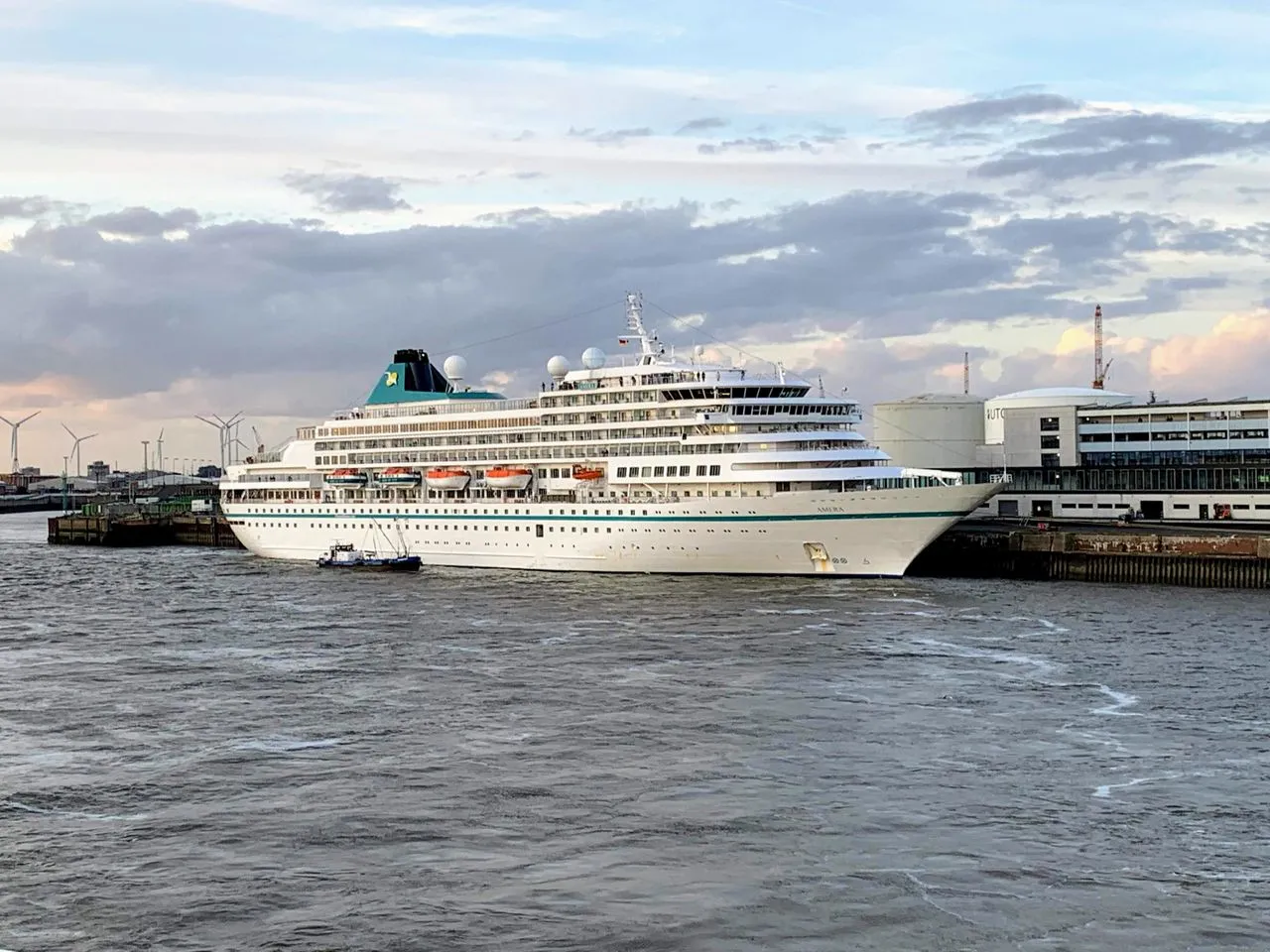 River cruise ship docked in a European city center at sunset